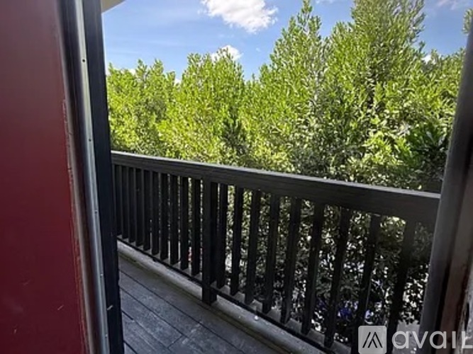 A balcony with a railing and trees in the background.