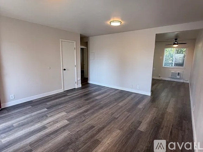 A room with wooden flooring and white walls.