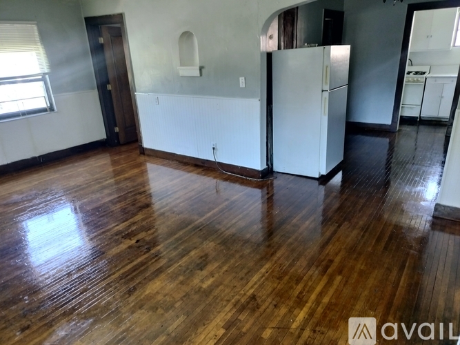 A room with wooden floors and a white wall.