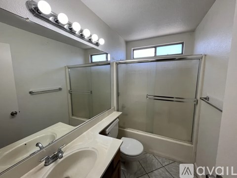A white tiled shower with a faucet and a drain.