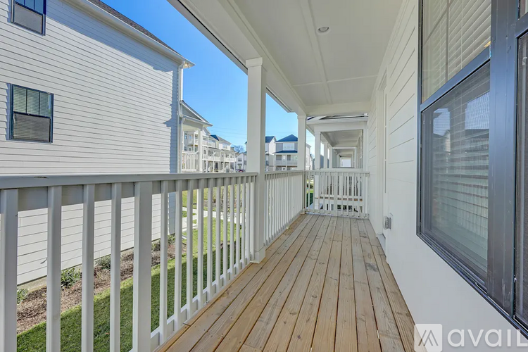 A white house with a wooden deck and a balcony.