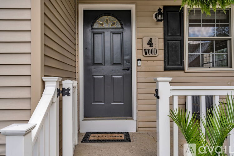 A house with a grey door and a sign that says 4 wood.