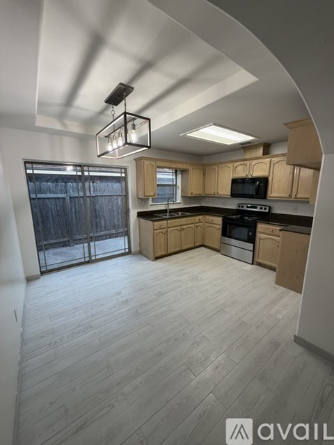 A kitchen with wooden cabinets and a black stove top oven.