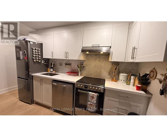 A kitchen with a stainless steel refrigerator, oven, and dishwasher.