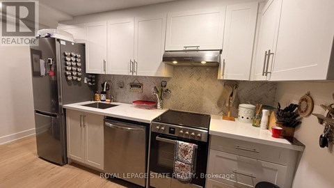 A kitchen with a stainless steel refrigerator, oven, and dishwasher.