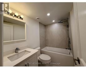 A bathroom with a toilet, sink, and bathtub.