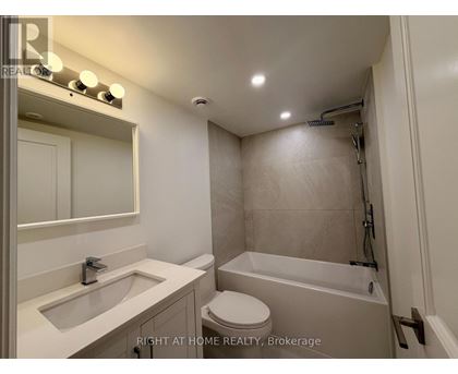 A bathroom with a toilet, sink, and bathtub.