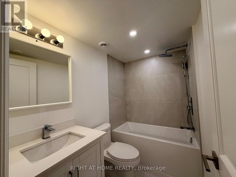 A bathroom with a toilet, sink, and bathtub.
