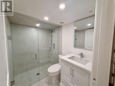 A bathroom with a toilet, sink, and shower.