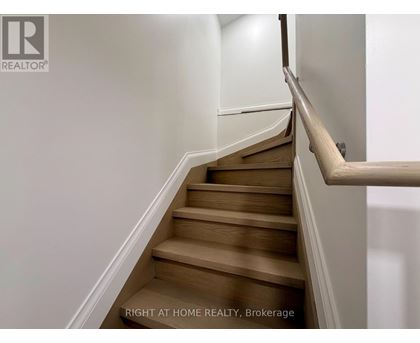 A staircase with wooden steps and a white railing.