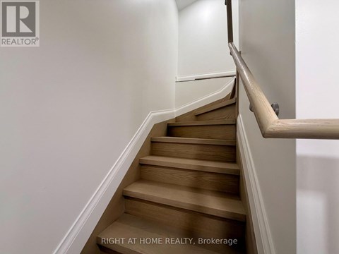A staircase with wooden steps and a white railing.