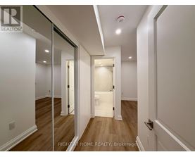 A hallway with a white door and a mirror on the wall.