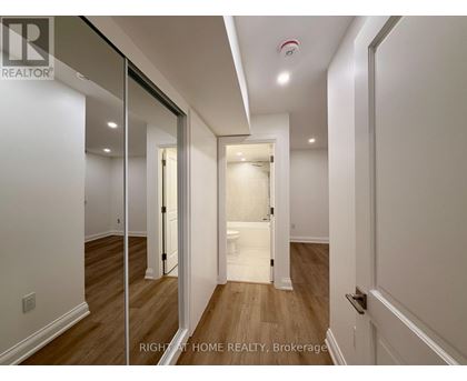 A hallway with a white door and a mirror on the wall.