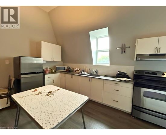 A kitchen with a table and a fridge.