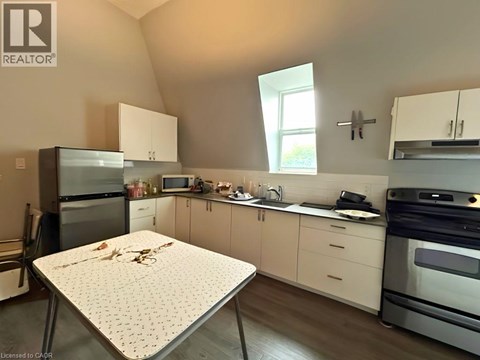 A kitchen with a table and a fridge.