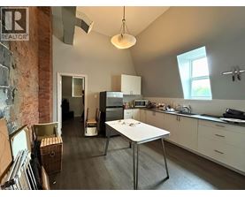 A kitchen with a table and a refrigerator.