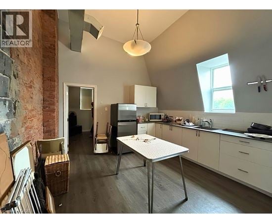 A kitchen with a table and a refrigerator.