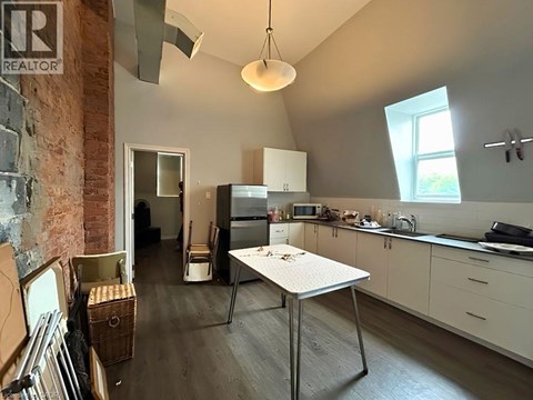 A kitchen with a table and a refrigerator.