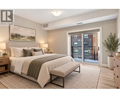 A bedroom with a large bed and a view of a building outside the window.