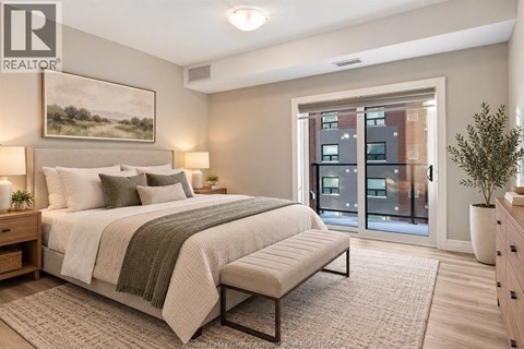 A bedroom with a large bed and a view of a building outside the window.