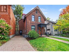 A brick house with a green lawn in front.