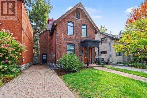 A brick house with a green lawn in front.