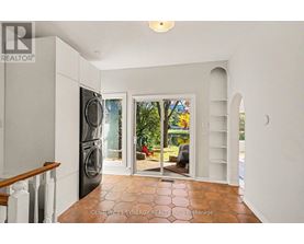 A kitchen with a refrigerator, sink, and a washing machine.