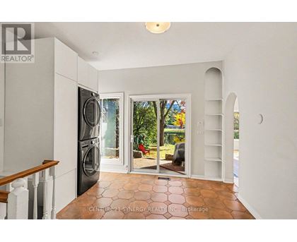 A kitchen with a refrigerator, sink, and a washing machine.