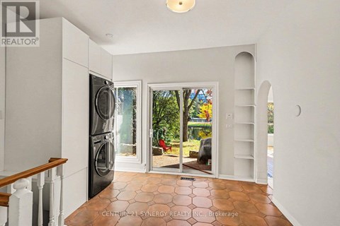 A kitchen with a refrigerator, sink, and a washing machine.