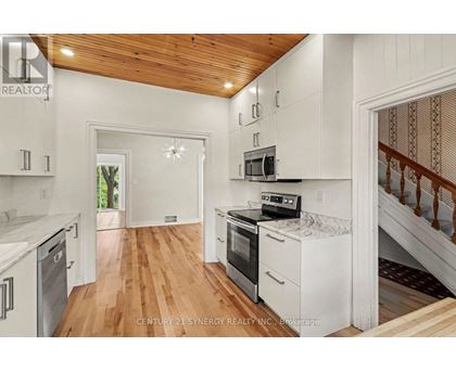 A kitchen with white cabinets and a wooden ceiling.