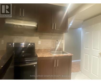 A kitchen with a black stove top oven and a granite counter top.