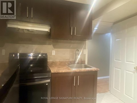 A kitchen with a black stove top oven and a granite counter top.