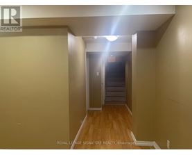 A hallway with a light on the ceiling and a door at the end.