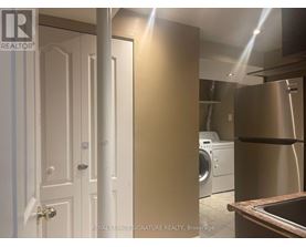 A white door is on the left and a stainless steel refrigerator is on the right.