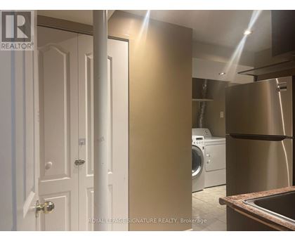 A white door is on the left and a stainless steel refrigerator is on the right.
