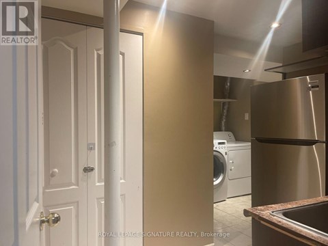 A white door is on the left and a stainless steel refrigerator is on the right.