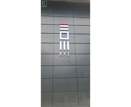 Exit sign on a building with a grey background.