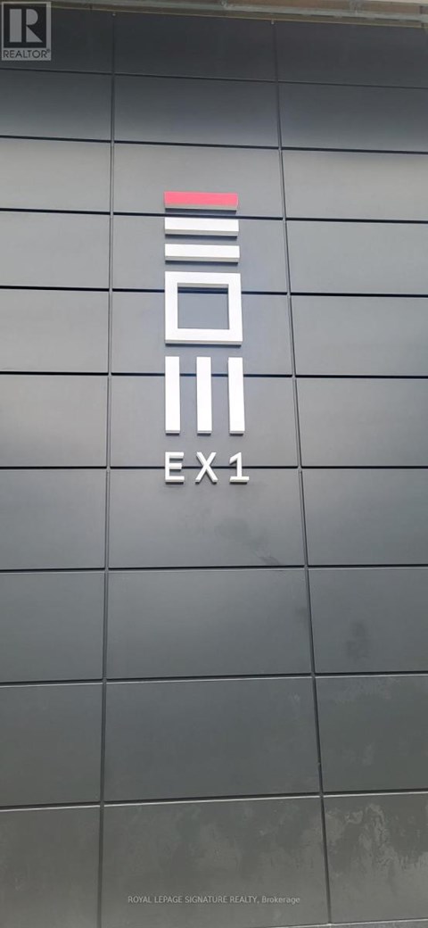 Exit sign on a building with a grey background.
