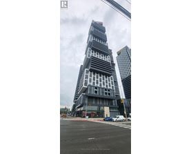 A tall building with a unique design stands out in the cityscape.