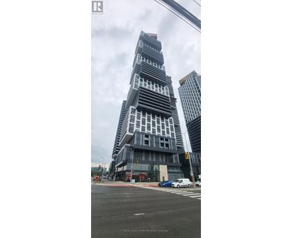 A tall building with a unique design stands out in the cityscape.