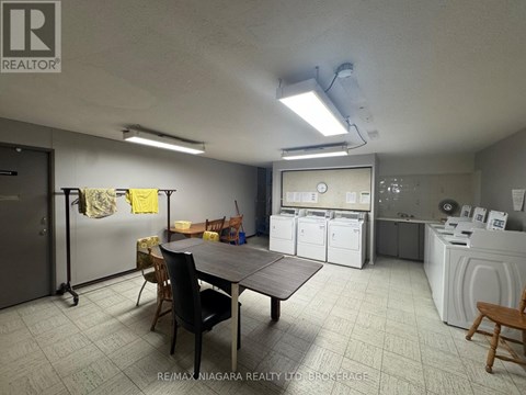 A laundry room with a washer and dryer, a table, chairs, and a refrigerator.
