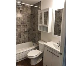 A bathroom with a toilet, sink, and bathtub.