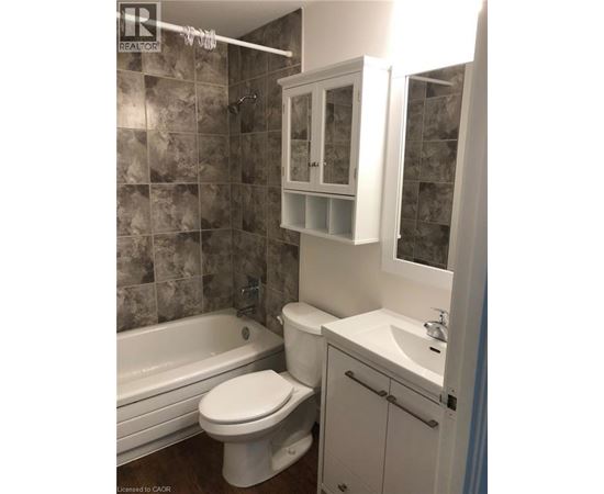 A bathroom with a toilet, sink, and bathtub.