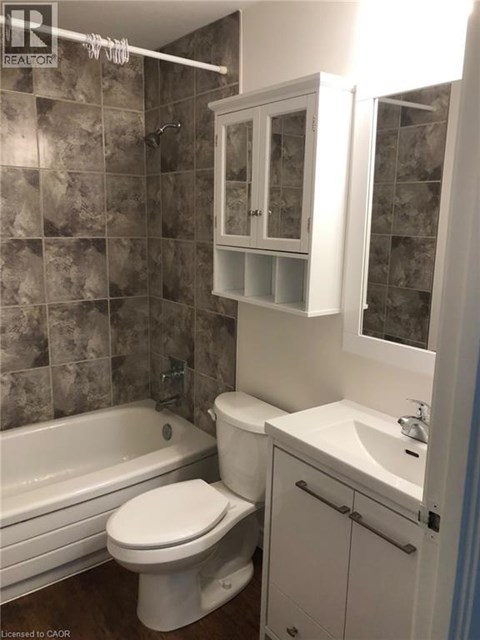 A bathroom with a toilet, sink, and bathtub.