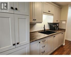 A kitchen with white cabinets and a granite countertop.