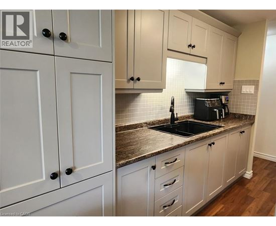 A kitchen with white cabinets and a granite countertop.