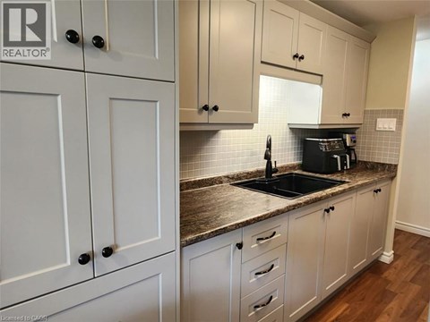 A kitchen with white cabinets and a granite countertop.