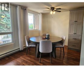A dining room with a round table and chairs.