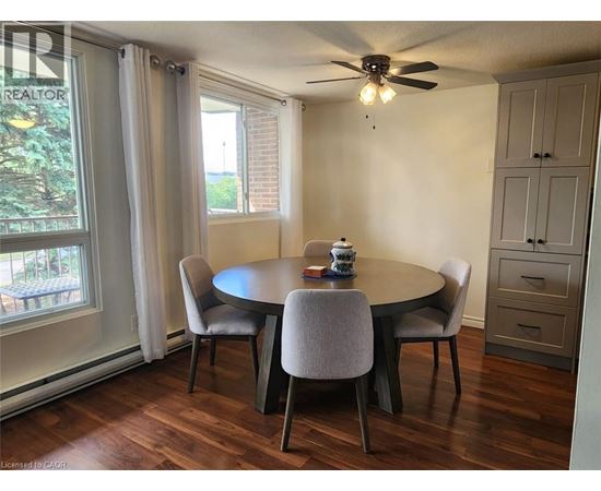 A dining room with a round table and chairs.