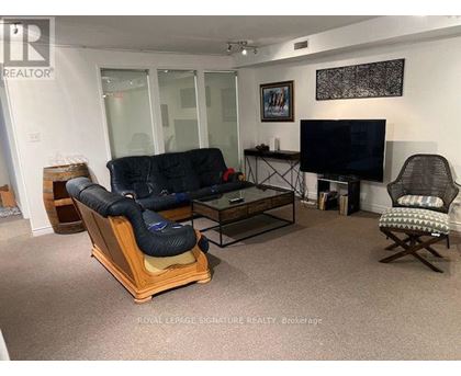 A living room with a black sofa and a TV.